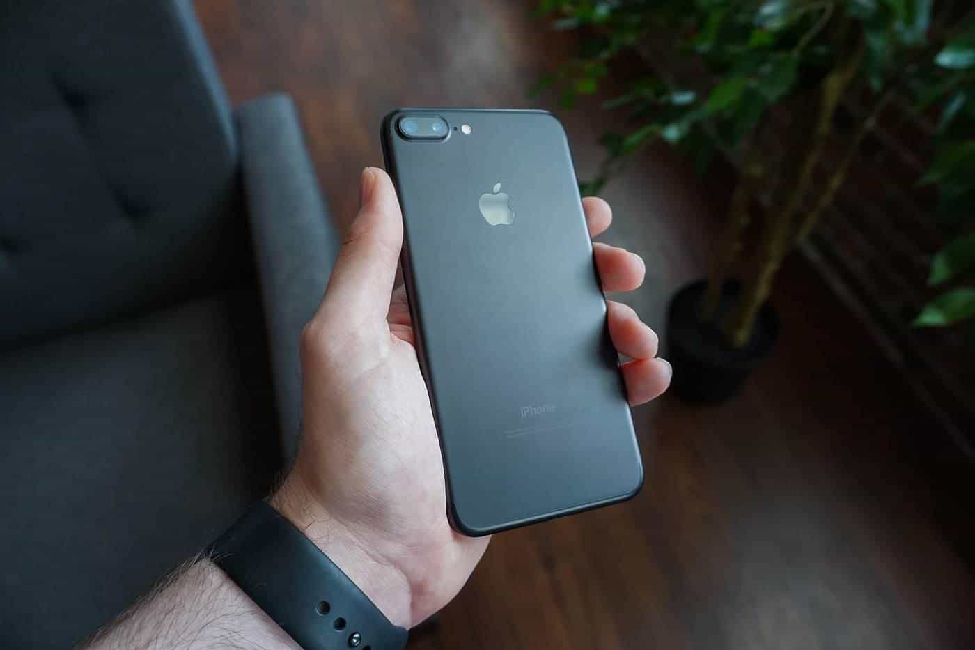 A hand holding a black smartphone