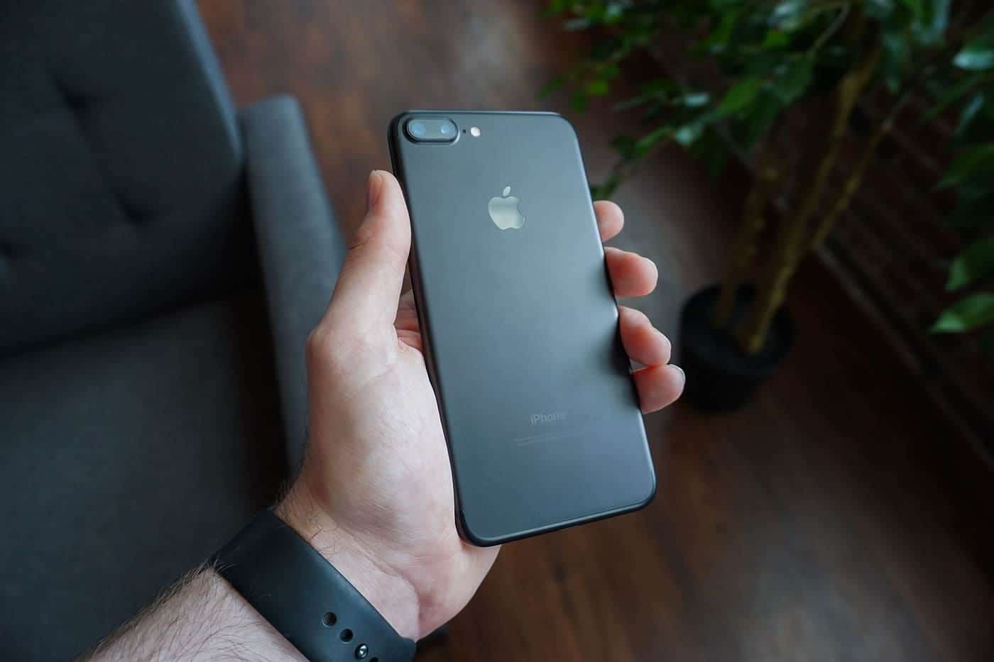 A hand holding a black smartphone