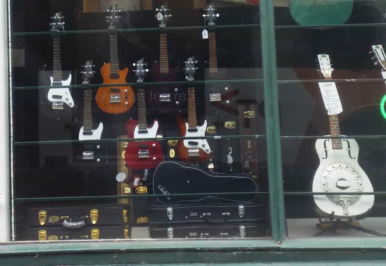 A shop window displaying guitars on a Melbourne street