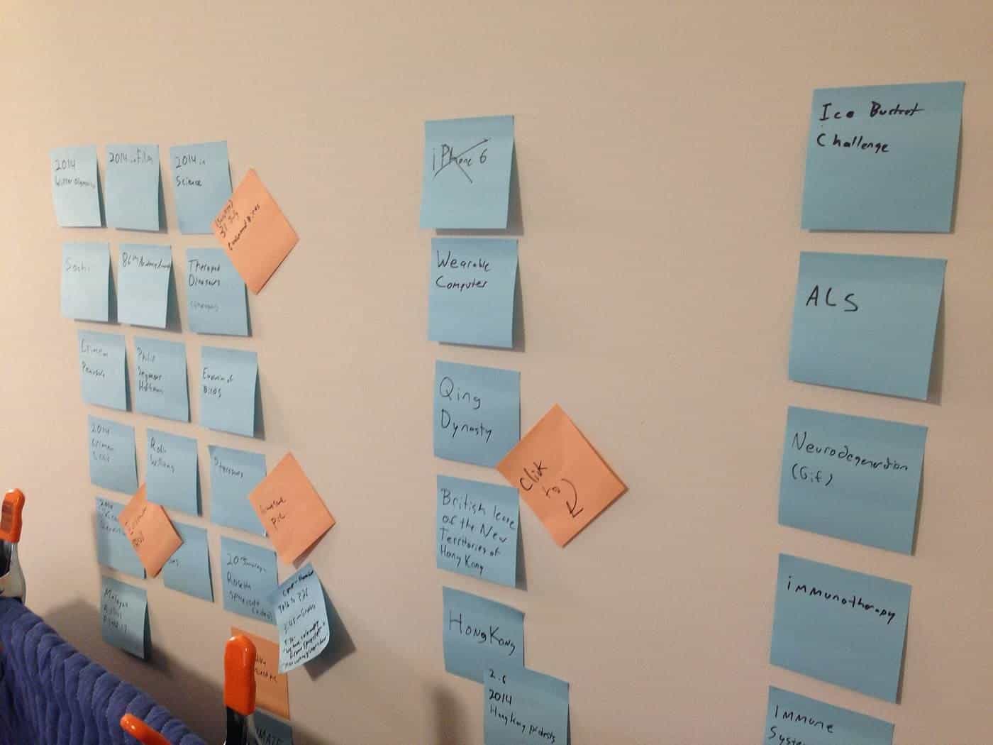 Blue and orange sticky notes arranged in columns on a wall