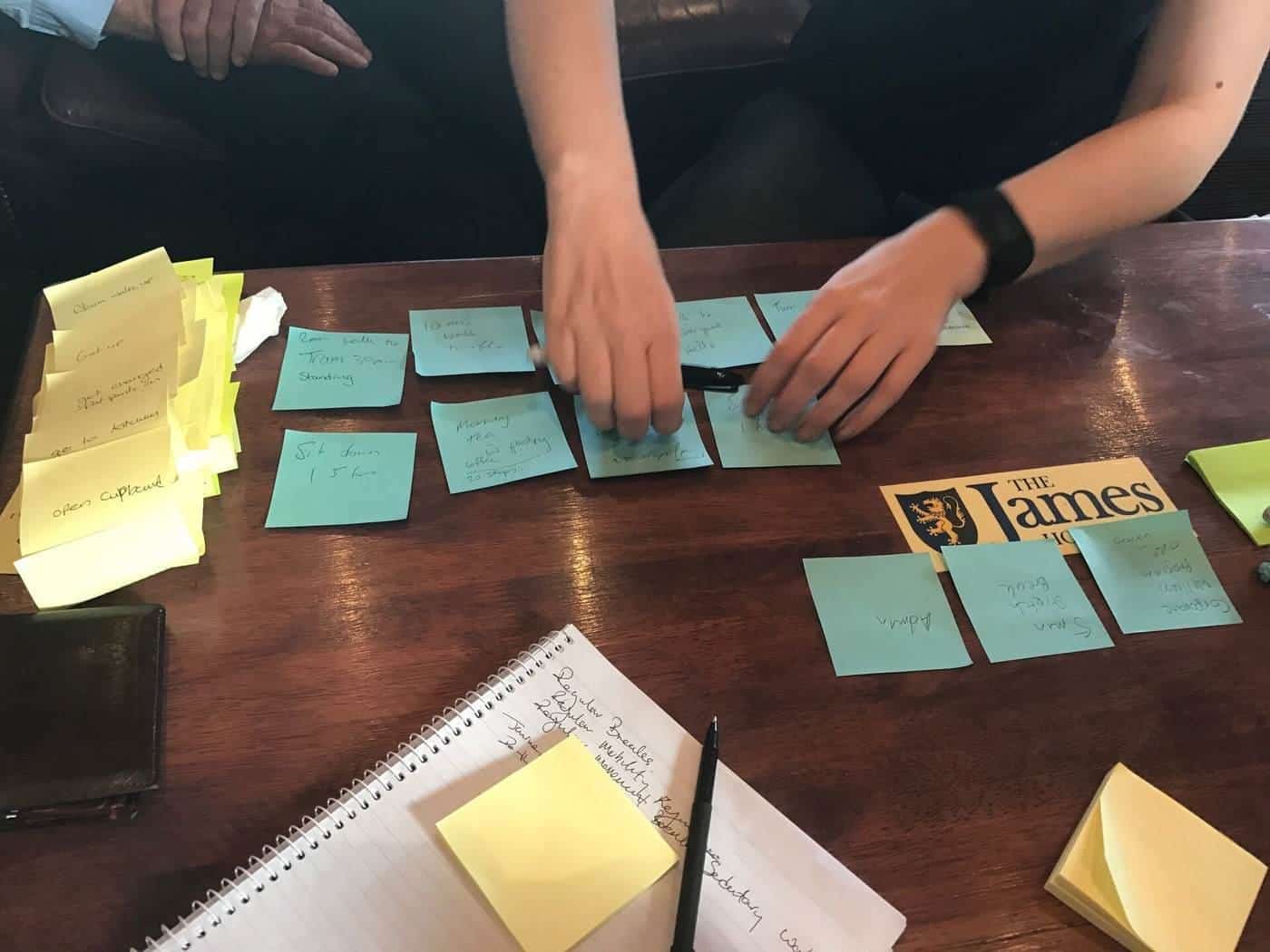 Hands arranging handwritten customer feedback cards on a table